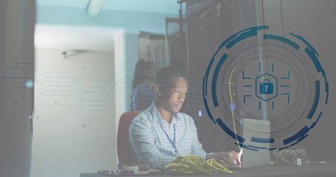 Network security engineer working on laptop in data center