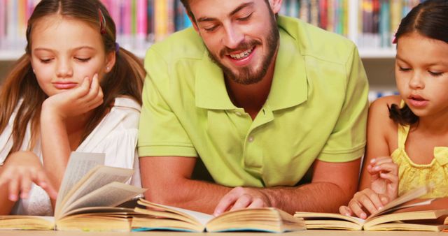 Happy Young Teacher Reading with Students in Library - Download Free Stock Images Pikwizard.com