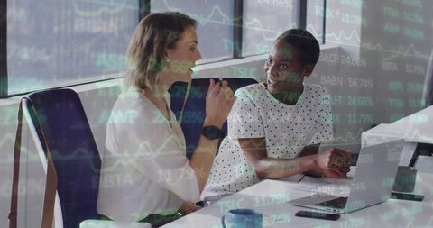 Diverse Women Discussing Financial Data with Overlaid Graphs