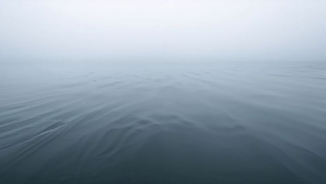 Misty Ocean Horizon Revealing Calm Ripples and Minimalist Blue Gradient
