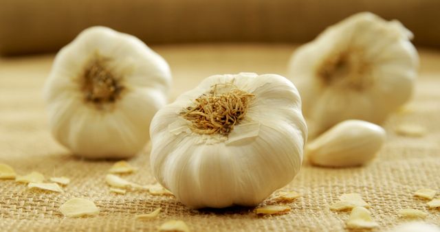 Close-Up of Fresh Garlic Bulbs on Textured Cloth - Download Free Stock Images Pikwizard.com