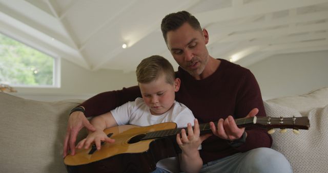 Father Teaching Son To Play Acoustic Guitar In Cozy Living Room - Download Free Stock Images Pikwizard.com