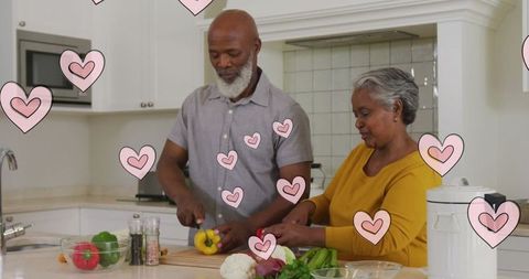 Senior African American Couple Cooking With Heart Decorations