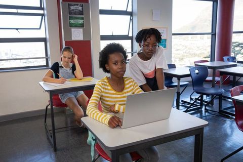 Diverse Female Students Collaborating in Bright Classroom Setting