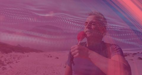 Hiker refreshing on beach adventure with red bottle