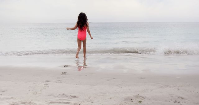 Young Girl in Swimsuit Running Toward Ocean on Beach - Download Free Stock Images Pikwizard.com