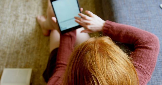 Redhead Woman Typing on Tablet at Home in Cozy Living Room - Download Free Stock Images Pikwizard.com