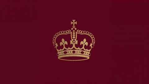 Golden british empire crown emblem on regal maroon background