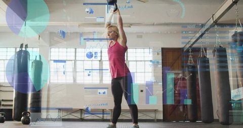 Female athlete performing kettlebell overhead press with digital fitness hud in gym