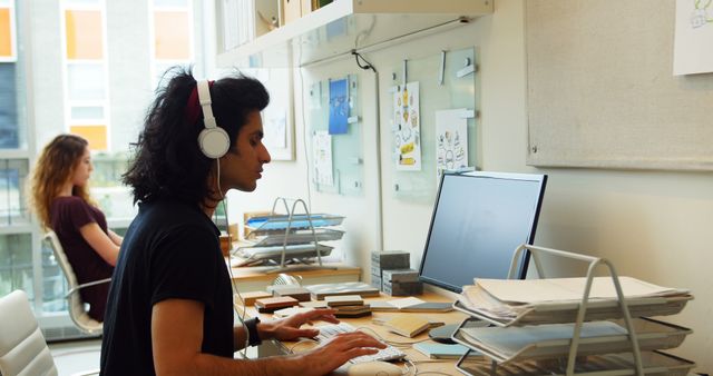 Focused Man Working at Desk with Headphones in Modern Office - Download Free Stock Images Pikwizard.com