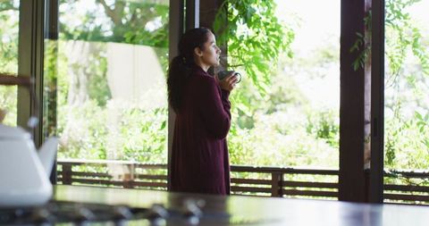 Woman Enjoying Morning Coffee by Large Windows