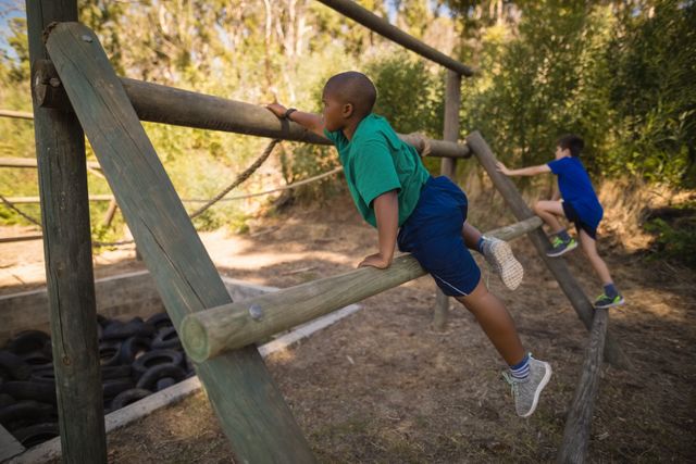 Boys exercising on outdoor equipment during obstacle course in boot camp