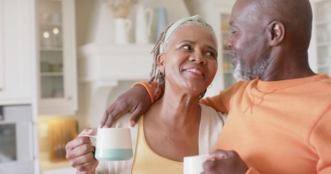 Senior Couple Embracing with Coffee in Modern Kitchen