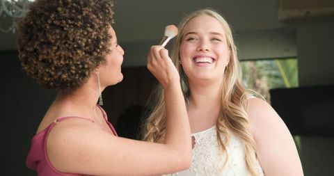 Bride and Bridesmaid Joyfully Preparing for Wedding