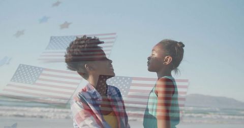 Mother and Daughter Connecting on Beach with American Flags Overlay