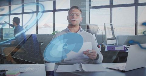 Reviewing interactive holographic data dashboard at modern office desk with laptop