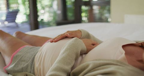 Pregnant Woman Gently Touching Belly at Home