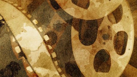 Sepia grunge film reels and filmstrip overlap evoking vintage cinema texture