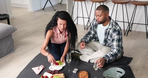 Couple Celebrating Together with Wine and Snacks at Home