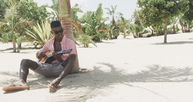 Relaxed Man Playing Guitar on Tropical Beach - Download Free Stock Images Pikwizard.com