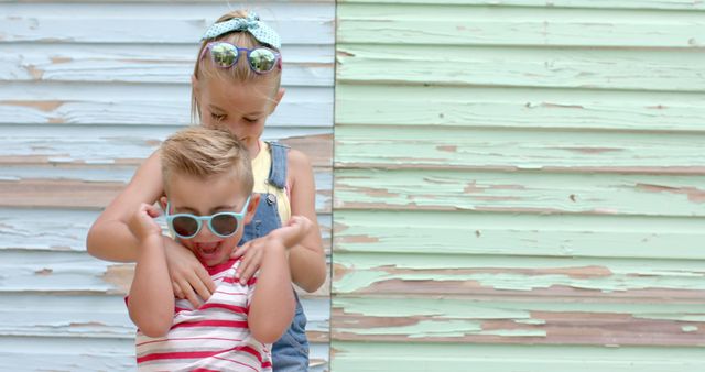 Siblings Playing and Laughing in Front of Vintage Wooden Wall - Download Free Stock Images Pikwizard.com