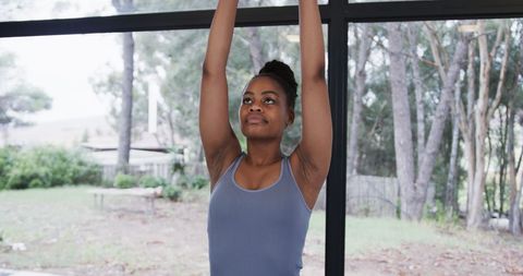 African American Woman Meditating in Bright Yoga Studio