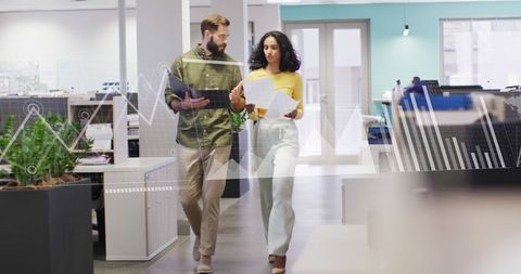 Colleagues Analyzing Reports with Graphs in a Modern Office
