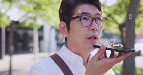 Professional man speaking into smartphone on urban sidewalk with voice assistant overlays