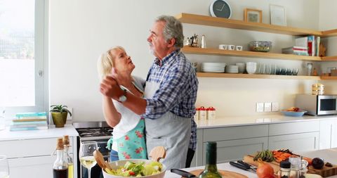 Senior Couple Dancing Joyfully in Contemporary Kitchen