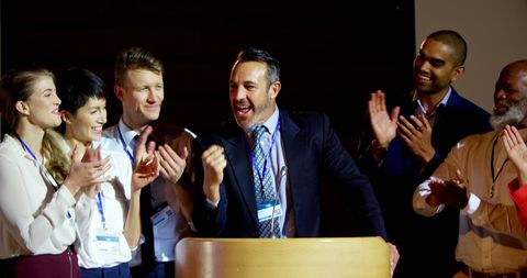Diverse colleagues celebrating speaker at business conference