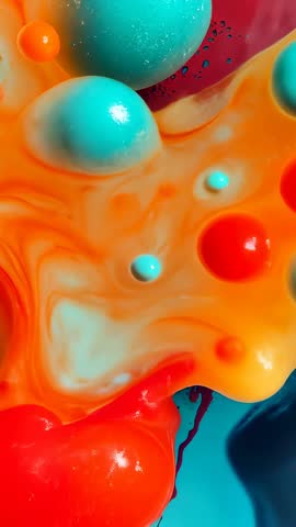 Macro liquids flowing: orange pigment spreading and turquoise merging in vertical clip