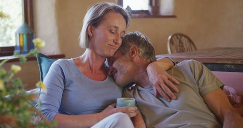 Senior Couple Embracing with Coffee in Cozy Living Room