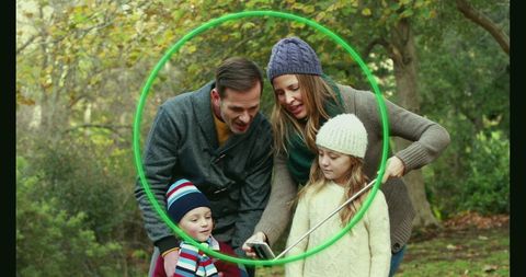 Happy Family Taking Selfie Outdoors with Green Hoop