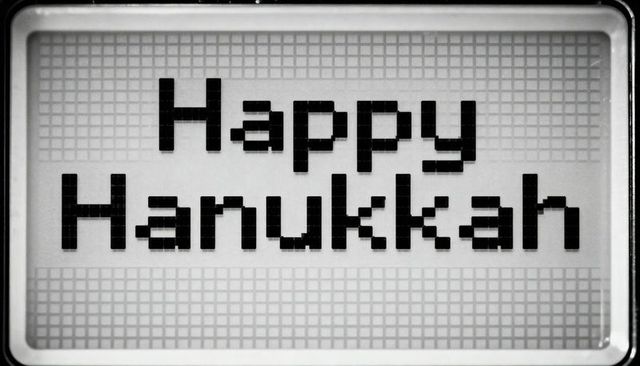 Retro dot-matrix display reading happy hanukkah monochrome pixel greeting sign