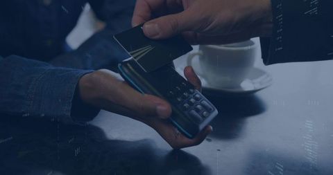 Processing contactless card payment at cafe with handheld pos reader and coffee cup