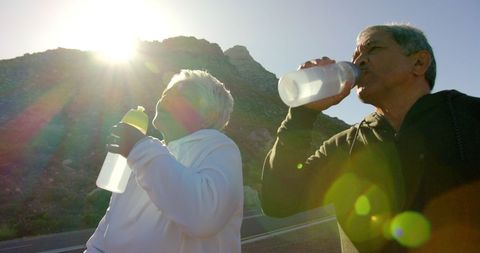 Active Senior Couple Enjoying Refreshment on Mountain Hike