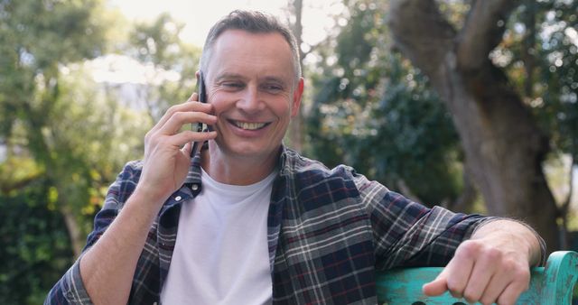 Smiling Man Having Phone Conversation in Outdoor Park - Download Free Stock Images Pikwizard.com