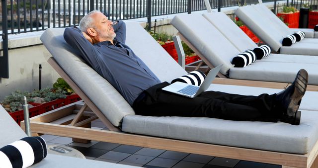 Senior Man Relaxing on Sun Lounger with Laptop on Rooftop Terrace - Download Free Stock Images Pikwizard.com