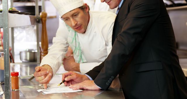 Chef and Businessman Discussing Recipes in Commercial Kitchen - Download Free Stock Images Pikwizard.com