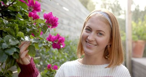 Young Woman Enjoying Blooming Bougainvilleas in Garden