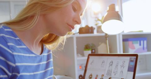 Female fashion designer creating sketch at her desk