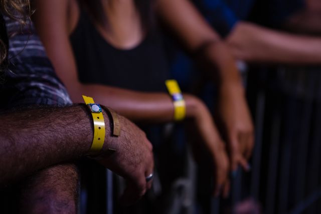 Friends Enjoying Rock Concert with Yellow Wristbands - Download Free Stock Photos Pikwizard.com