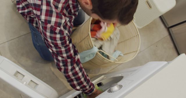 Busy caucasian man wearing checked shirt and doing laundry in kitchen - Download Free Stock Photos Pikwizard.com