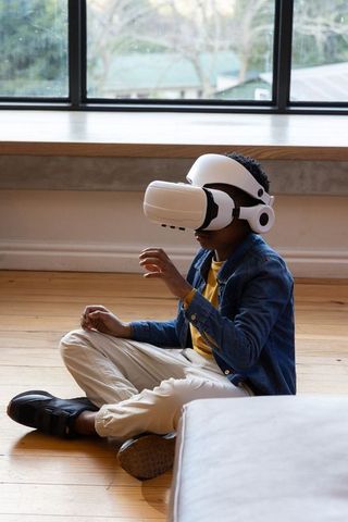 African American Boy Exploring Virtual Reality at Home Wearing White VR Headset