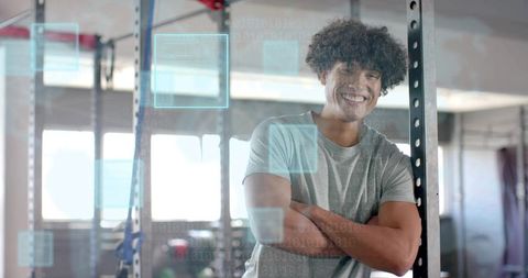 Smiling male trainer in modern gym with digital overlay