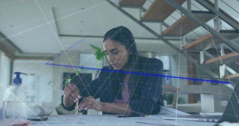 Female designer sketching with compass in modern workspace