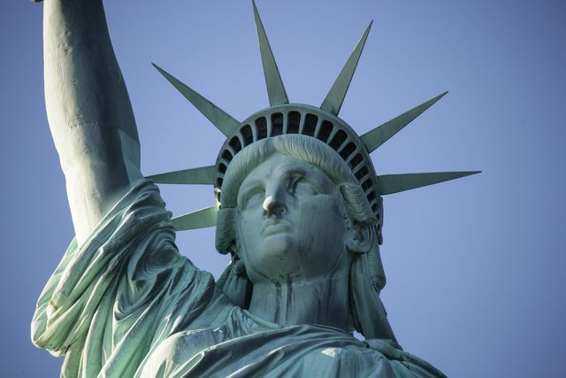 Close-up view of the iconic Statue of Liberty, showcasing the intricate details of its design against a clear blue sky. Ideal for travel brochures, educational materials, symbols of freedom, and American heritage content.