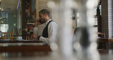 Businessman Talking on Smartphone in Cozy Cafe