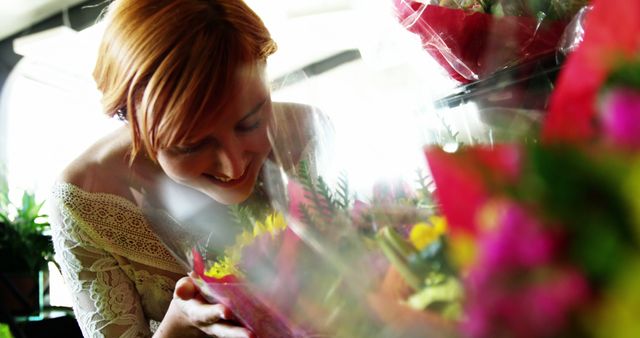 Smiling Woman with Red Hair Enjoying Fresh Flowers in Market - Download Free Stock Images Pikwizard.com