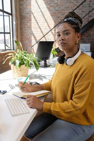 Focused African American Woman Working in Loft Office with Mustard Sweater